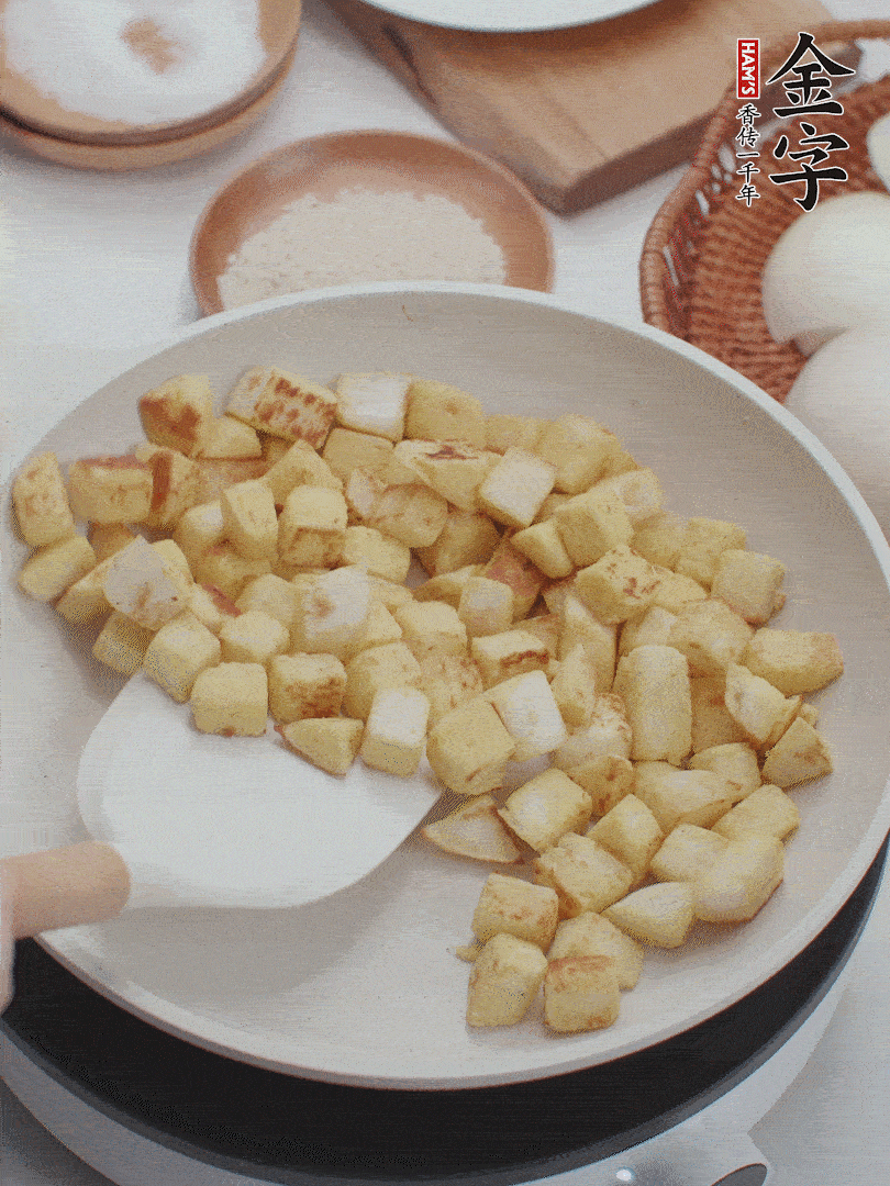 起鍋熱油，倒入饅頭丁，小火煎至蛋液凝固定型再翻面，饅頭丁部煎至金黃時盛起待用。